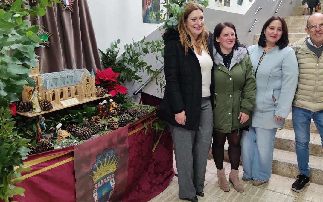 Una colección de fotos de belenes antiguos acompaña la entrada de los clientes al mercado